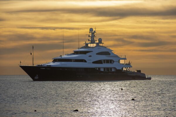 Stunning view of a luxury yacht sailing at sunset in Cabo San Lucas, Mexico's tranquil waters.